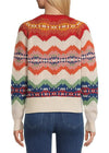 Person wearing a colorful patterned sweater with blue jeans on a white background
