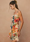 Woman wearing a floral two-piece outfit against a beige background