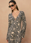 Woman wearing a patterned dress against a beige background