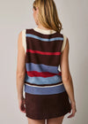 A woman shown from the back wearing a sleeveless knit sweater vest with horizontal stripes in brown, cream, light blue, and red, paired with a brown mini skirt, against a plain light gray studio background.