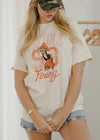 Person wearing a graphic t-shirt with text and graphics, standing indoors.
