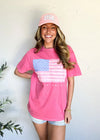 Woman wearing a pink t-shirt with an American flag design and a matching pink cap.