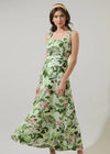 Woman wearing a green floral dress against a plain background