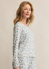 Woman wearing a floral pajama set against a beige background