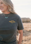 Woman wearing a t-shirt with 'Living on Farmer Time' text in a field.