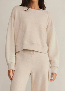  Person wearing a beige sweatshirt and pants set on a plain background