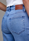 Blue jeans with a leather patch and brand logo on a gray background