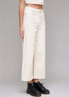Person wearing white wide-leg pants and black boots on a plain background