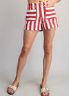 Red and white striped shorts worn by a person on a gray background