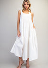 Woman wearing a white sleeveless dress against a plain background