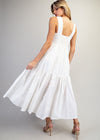 Woman wearing a white dress against a plain background