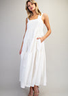 Woman wearing a white dress against a plain background