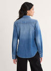 Woman wearing a blue denim shirt on a light gray background