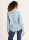 Person wearing a light blue denim shirt and jeans on a white background