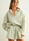 Woman wearing a green and white striped outfit against a plain background