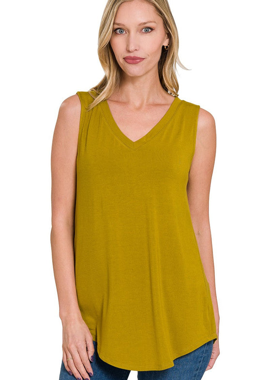 Woman wearing an olive mustard sleeveless top on a white background
