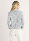 Woman wearing a patterned sweater with a plain background