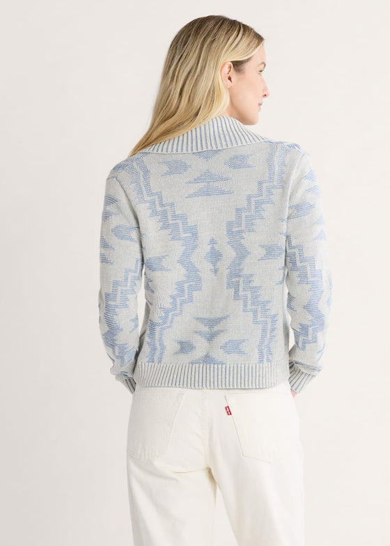 Woman wearing a patterned sweater with a plain background
