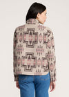 Person wearing a patterned shirt with a neutral background