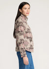 Woman wearing a patterned shirt with a plain background