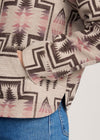 Close-up of a patterned shirt with geometric design and blue jeans.