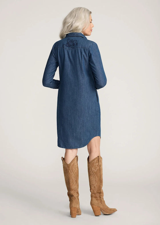 Woman wearing a blue denim dress with a high-low hemline and brown knee-high boots on a white background