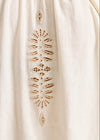 Close-up of a beige fabric with intricate cut-out pattern