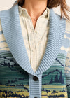 Close-up of a patterned cardigan with a blue collar and geometric design.