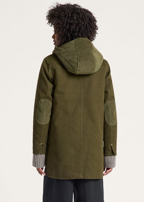 Person wearing a green coat with hood and elbow patches on a white background