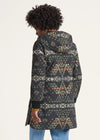 Person wearing a patterned coat on a white background