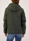 Person wearing a green quilted jacket on a white background