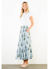 Woman wearing a white top and a long floral skirt on a white background