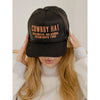 Black cap with text worn by a person on a neutral background