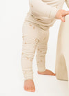 Child wearing beige pants with subtle pattern on a white background