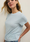 Woman wearing a light blue t-shirt against a plain background