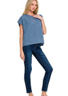 Woman wearing a blue top and jeans on a white background