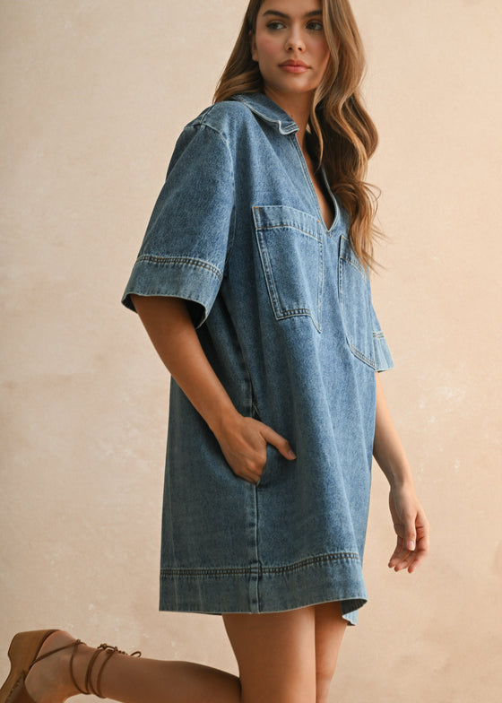 Woman wearing a denim dress against a beige background