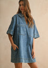 Woman wearing a denim dress against a beige background