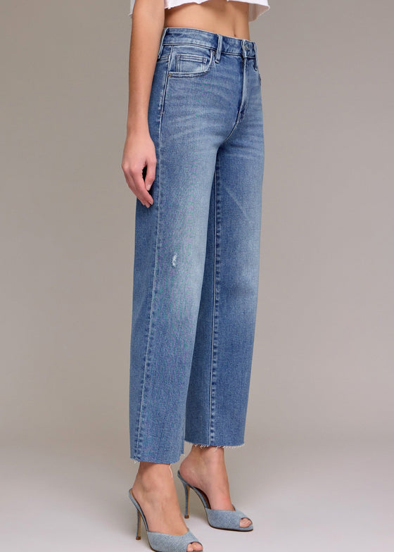 Person wearing light blue jeans on a plain background