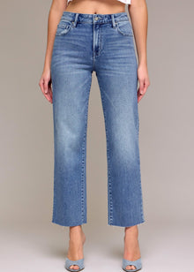  Blue jeans worn by a person on a plain background