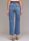 Person wearing blue jeans on a plain background