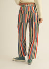 Person wearing colorful striped pants on a plain background