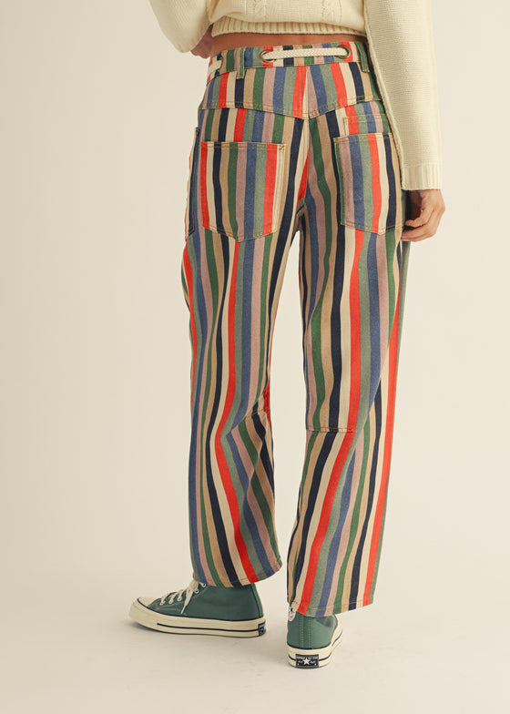 Person wearing colorful striped pants on a plain background