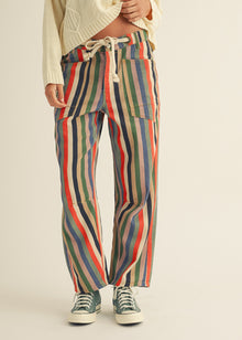  Multicolored striped pants worn by a person on a beige background