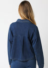 Person wearing a blue denim jacket on a white background