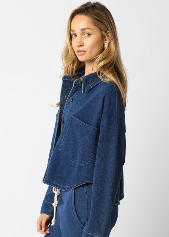 Woman wearing a blue denim jacket and pants on a white background