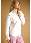 Woman wearing a white shirt and pink checkered pants against a beige background