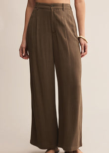  Brown wide-leg pants worn by a person on a beige background