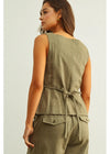 Woman wearing an olive green sleeveless top and pants set on a light gray background