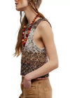 Woman wearing a patterned sleeveless top with a necklace on a white background